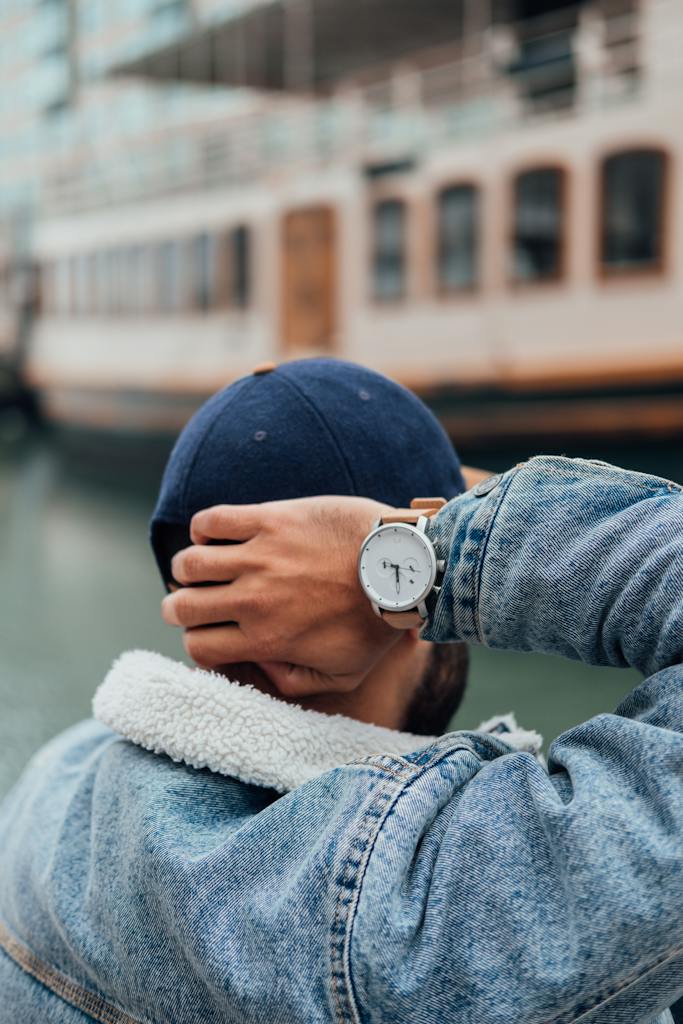 Person Wearing Blue Denim Jacket and Silver Round Analog Watch