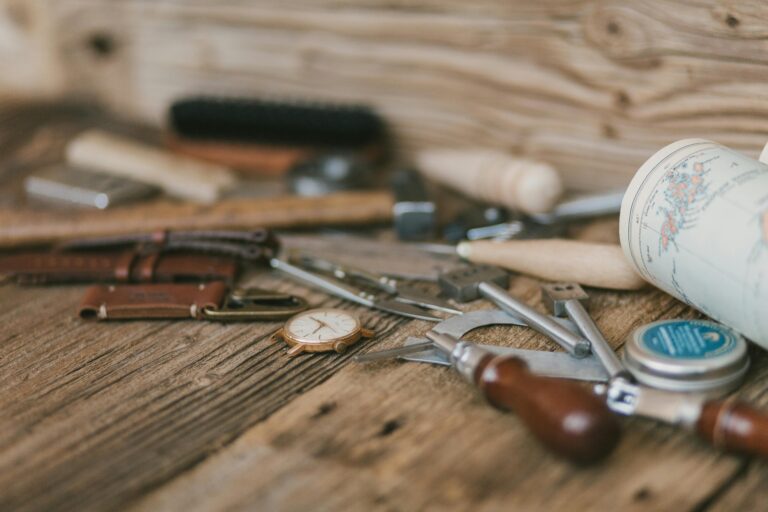 Various tools and accessories for watch maintenance neatly arranged on a wooden table for easy access and organization.